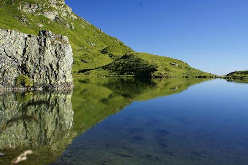 a reflection of a mountain in a body of water at Hotel Wechselberger by Alpeffect Hotels in Saalbach Hinterglemm