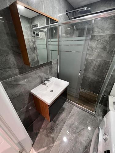 ein Bad mit einem Waschbecken, einer Dusche und einem Spiegel in der Unterkunft Zeytinburnu merkezi konumda, sıfır daire & eşyalar in Istanbul