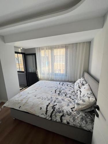 Schlafzimmer mit einem Bett und einem Fenster in der Unterkunft Zeytinburnu merkezi konumda, sıfır daire & eşyalar in Istanbul