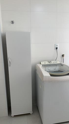 eine Küche mit einem weißen Kühlschrank und einer Waschmaschine in der Unterkunft Apto térreo novo 2 Dorm - próximo ao Centro in Poços de Caldas