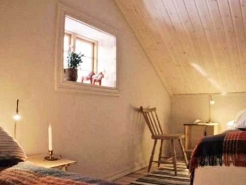 a bedroom with a bed and a window and a chair at Holiday home MORA III in Börka