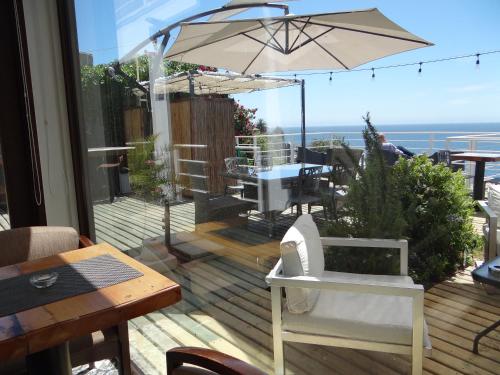 a patio with a table and an umbrella on a deck at Laura del Mar Hotel Boutique in Concón