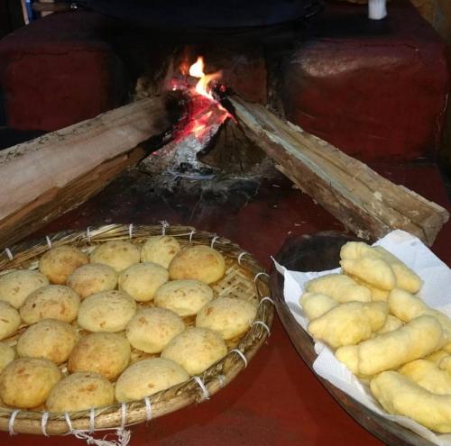 two baskets of potatoes in front of a fire at Fazendinha da Canastra in Vargem Bonita