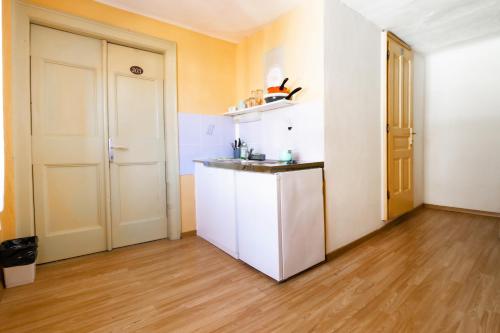 a kitchen with a white refrigerator and a wooden floor at Hostel Martin in Koper