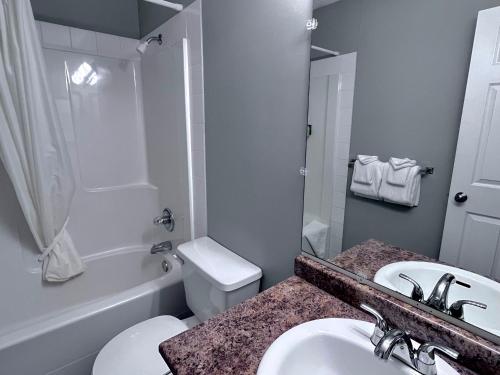 a bathroom with a sink and a toilet and a tub at Canadian Rockies Chalets by Trilink - 2 & 3 Bedroom Condos - Self Check-In - Walking Distance to Downtown - Free Parking - Pet-Friendly - No AC in Canmore