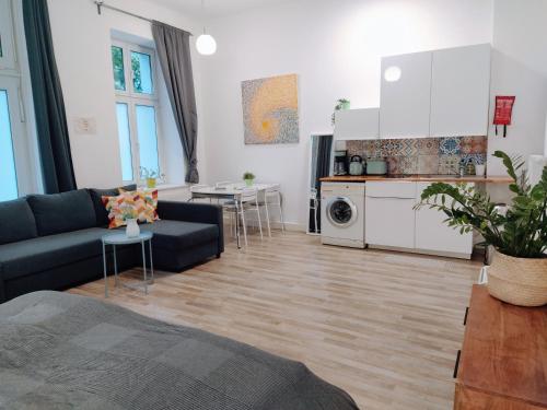 a living room with a couch and a kitchen at Cozy studio in Friedrichshain, 4 quiet guests only in Berlin