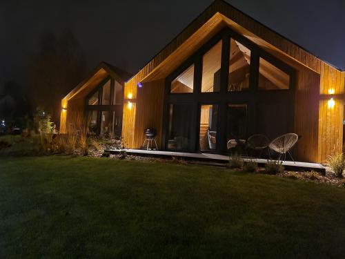 a house with large glass windows at night at Wimer Domki in Wysowa-Zdrój
