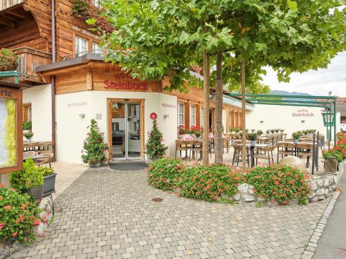 a restaurant with tables and chairs in front of a building at Hotel Steinbock in Brienz