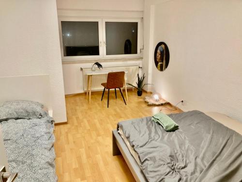 Schlafzimmer mit einem Bett, einem Tisch und einem Fenster in der Unterkunft Taunus top floor Balkon Altstadt Messe Frankfurt 10 min in Oberursel