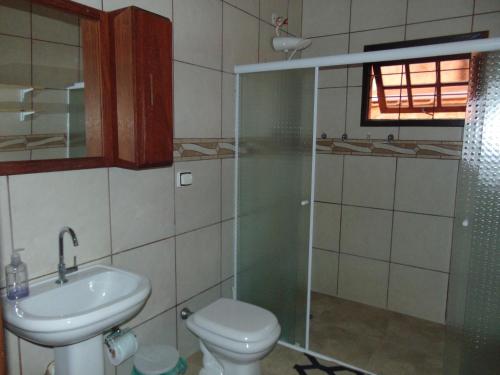 a bathroom with a toilet and a sink and a shower at Rancho do Colega in Santa Branca