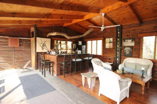 sala de estar con techos de madera, mesa y sillas en Masodini Game Lodge, en Hoedspruit