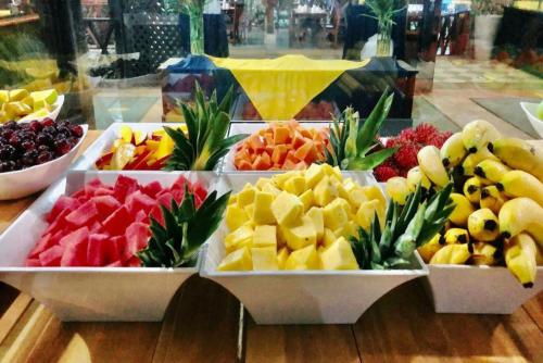 una muestra de diferentes frutas en bandejas sobre una mesa en Hotel Punta Leona, en Jacó