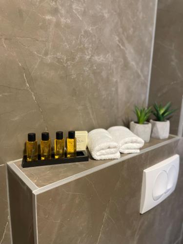 a shelf in a bathroom with three bottles of essential oils at Residence 33 in Sarajevo