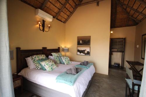 a bedroom with a bed with white sheets and pillows at Masodini Game Lodge in Hoedspruit