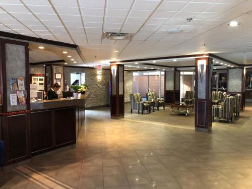 a lobby with a person sitting at a bar at Nomad Hotel & Suites in Fort McMurray
