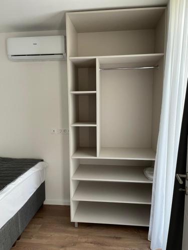 a closet with white shelves and a bed in a room at Residence 33 in Sarajevo