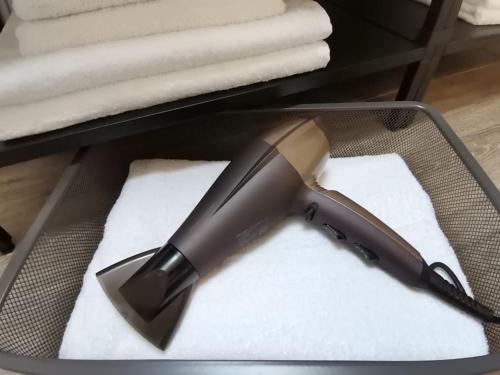 a black hair dryer sitting on top of white towels at Fewo "Am Bienenstock" in Dallgow-Döberitz in Dallgow