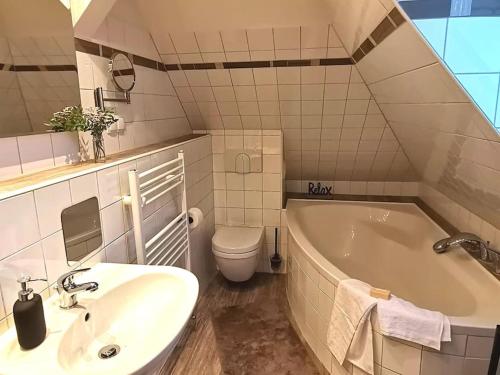 La salle de bains est pourvue d'un lavabo, d'une baignoire et de toilettes. dans l'établissement Fewo "Am Bienenstock" in Dallgow-Döberitz, à Dallgow