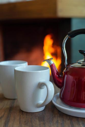 two cups and a tea kettle on a table with a fireplace at Casa Cielo en Chena Magica in Maipú