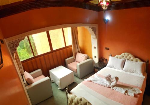 a bedroom with a bed and a chair and a mirror at Hôtel Restaurant Les Etoiles Du Toubkal in Imlil