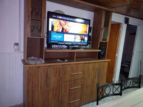 a television on top of a wooden entertainment center at Hermosa casa de vacaciones en Mendoza in Guaymallen