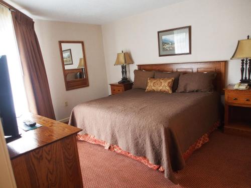 a bedroom with a bed and a desk and a window at Heart of Gatlinburg in Gatlinburg