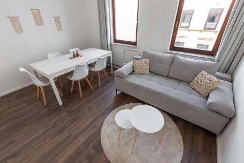 a living room with a couch and a table at Koje Eins I Großes Apartment mit 2 Schlafzimmern in Bremerhaven