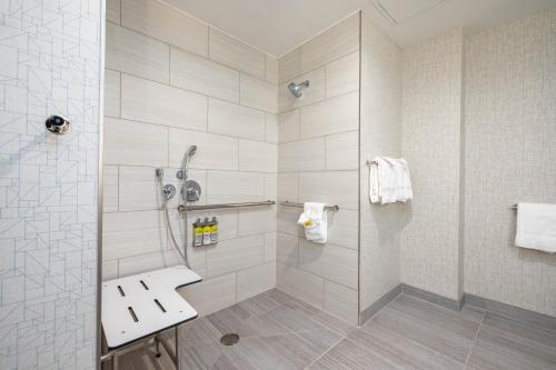 a white tiled bathroom with a shower and a sink at Holiday Inn Express & Suites - San Jose Silicon Valley, an IHG Hotel in San Jose