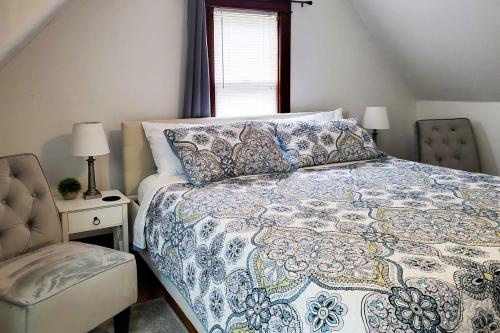 ein Schlafzimmer mit einem Bett, einem Stuhl und einem Fenster in der Unterkunft Charming Home Less Than One block to Lake Superior! in Ontonagon