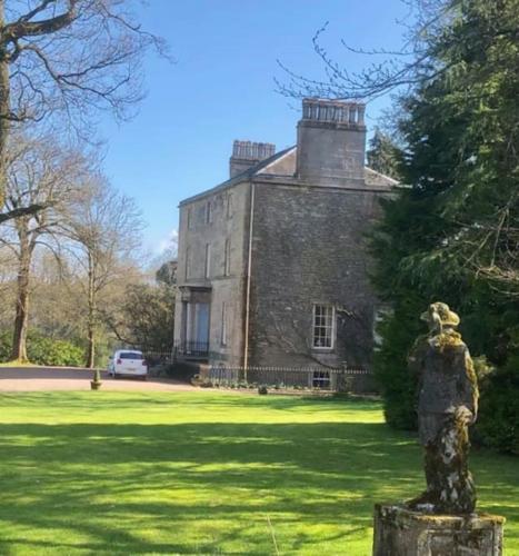 a statue in front of an old building at Unique Orchard Lodge for couples with hot tub in Strathaven