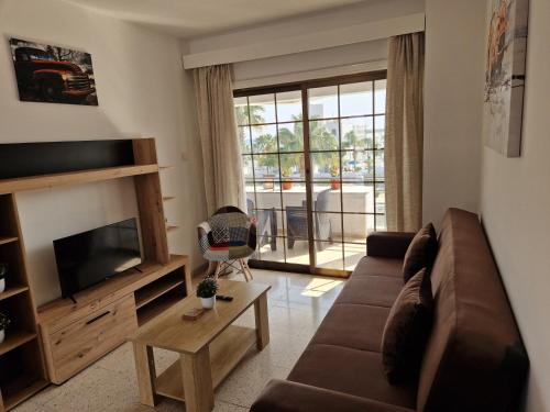 a living room with a couch and a television at La Veranda Sea View apartments in Larnaca