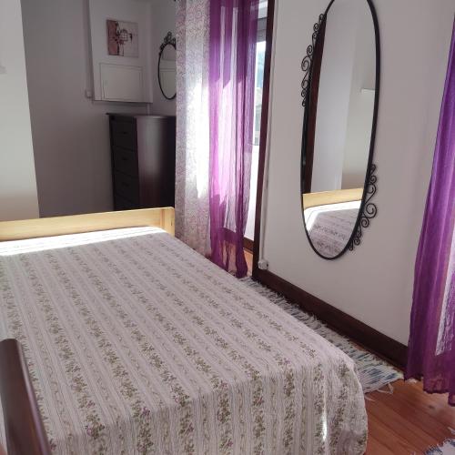 a bedroom with a bed and a mirror at Casinha da Sobreira in Penacova