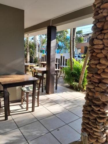 a patio with tables and chairs in a restaurant at Pousada das Palmeiras in Garopaba
