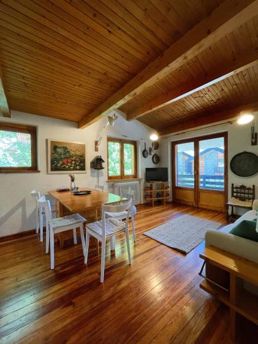 un salon avec une table, des chaises et un canapé dans l'établissement Accogliente chalet in mansarda, à Courmayeur
