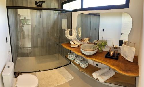 a bathroom with a sink and a toilet and a mirror at Pipa Sunset Villa in Pipa