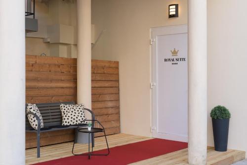 a hallway with a bench and a door with a sign at ROYAL SUITE, Ljubljana in Ljubljana