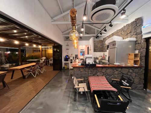 a restaurant with a counter and tables and chairs at Morning Beach Pension in Jeju