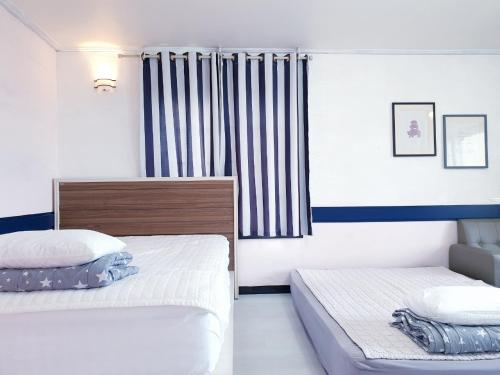 a bedroom with two beds and a window at Morning Beach Pension in Jeju