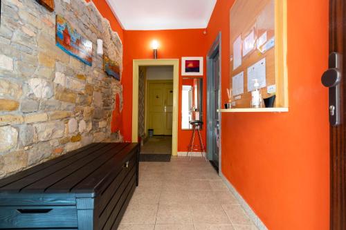 un pasillo con paredes de color naranja y un banco de madera en Hostel Martin, en Koper