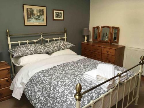 1 dormitorio con cama, tocador y espejo en Ravens Rest, en Llanwrda
