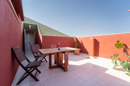 un patio con una mesa de madera y 2 sillas en Duplex Luz en Jaén