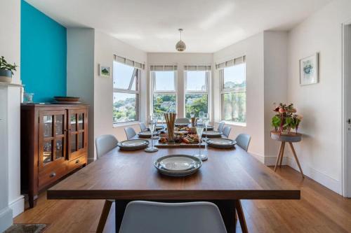 a dining room with a wooden table and chairs at Sea View House in Cornwall Fishing Village in St Austell