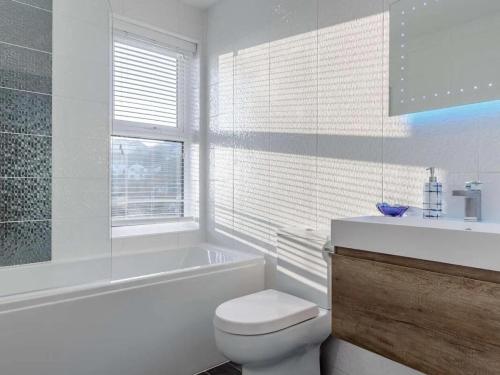 a bathroom with a toilet and a tub and a sink at Sea View House in Cornwall Fishing Village in St Austell