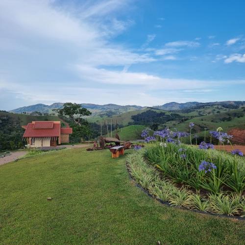 a park with a bench and flowers in a field at Lavandas de Cunha Pousada Boutique in Cunha