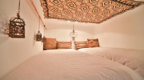 two beds in a room with a ceiling at Nadi's Home – Heart of Budapest in Budapest