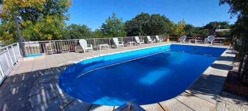 ein großer Pool mit Stühlen um ihn herum in der Unterkunft cabañas La Amelia Premium con piscina privada 2 personas in Mina Clavero