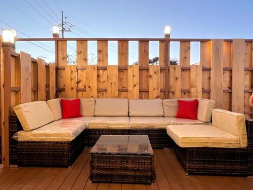 a couch on a patio with a wooden fence at Morning Beach Pension in Jeju