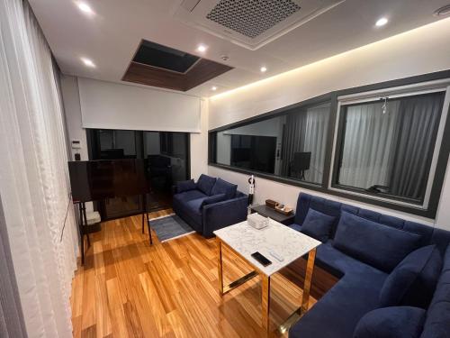 a living room with a blue couch and a table at Morning Beach Pension in Jeju