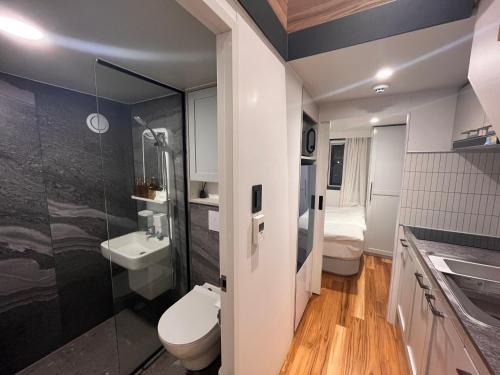 a bathroom with a toilet and a shower and a sink at Morning Beach Pension in Jeju