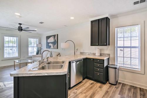 a kitchen with black cabinets and a sink at Chic Cottage Retreat with Grill, 2 Mi to MSU! in Starkville